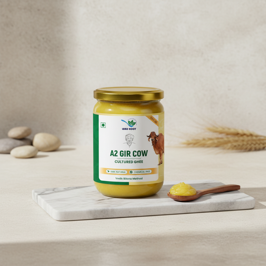 Jar of A2 Gir Cow Cultured Ghee with a spoonful on a wooden board